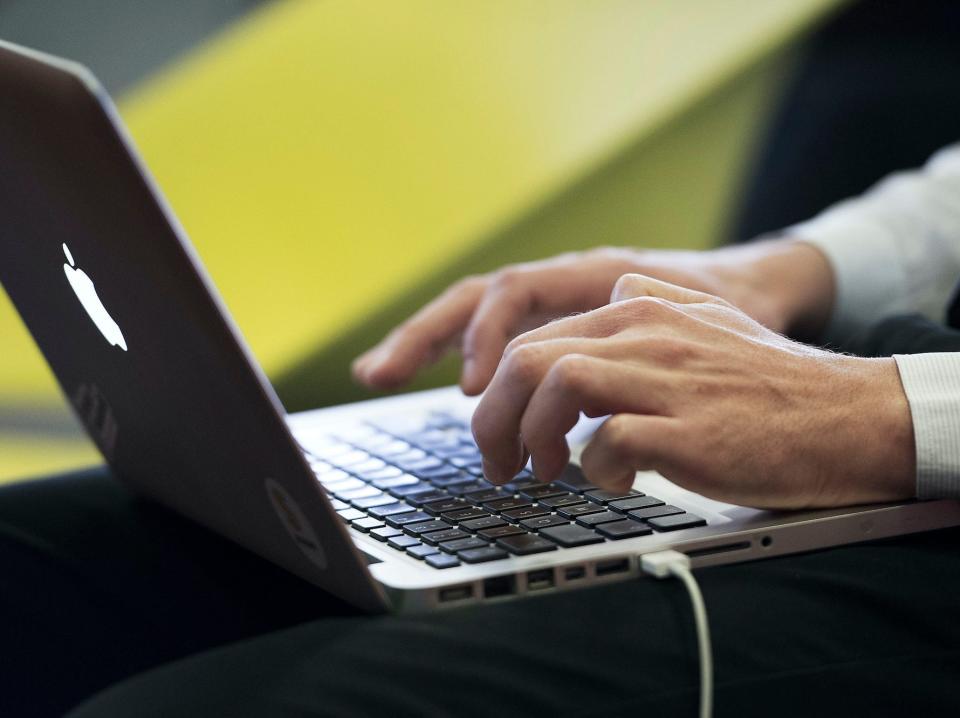 a person types on a laptop