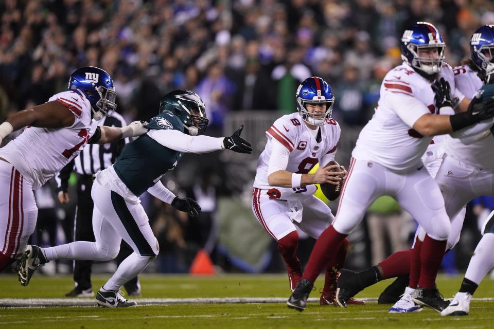 New York Giants quarterback Daniel Jones, center right, tries to scramble as Philadelphia Eagles linebacker Haason Reddick, center left, tries to stop him during the first half of an NFL divisional round playoff football game, Saturday, Jan. 21, 2023, in Philadelphia. (AP Photo/Matt Slocum)