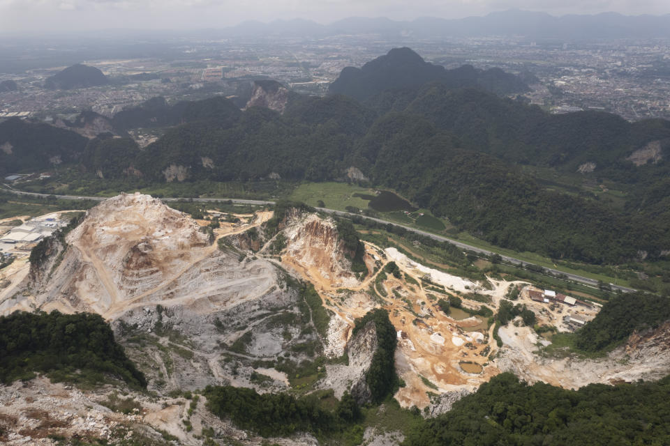 Deforested mountains from massive limestone quarries are seen in Ipoh, Perak state Malaysia, Friday, Nov. 5, 2021. Deforestation affects the people and animals where trees are cut, as well as the wider world and in terms of climate change, and cutting trees both adds carbon dioxide to the air and removes the ability to absorb existing carbon dioxide. World leaders are gathered in Scotland at a United Nations climate summit, known as COP26, to push nations to ratchet up their efforts to curb climate change. (AP Photo/Vincent Thian)