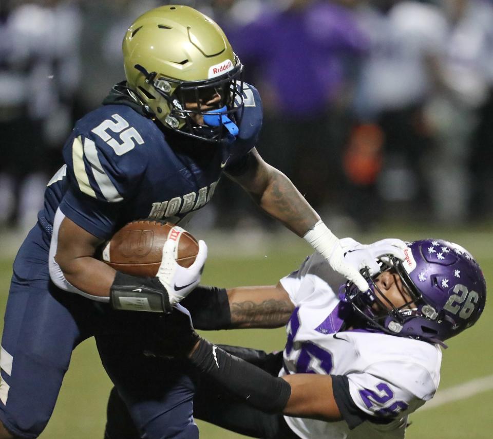 Archbishop Hoban running back Caleb Jones fends off Barberton linebacker Xzavier Macon during a Division II regional quarterfinal Nov. 3 in Akron.