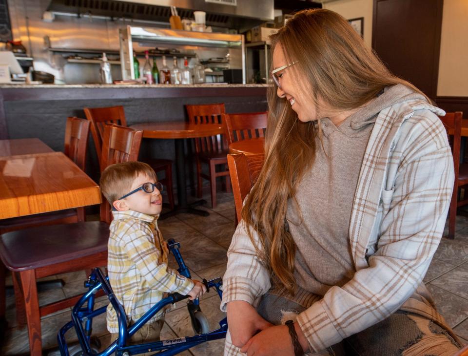 Shaye Merryman, right, smiles at her 4-year-old son Landon scooting during an interview at the Moonlight Cafe in Dover.