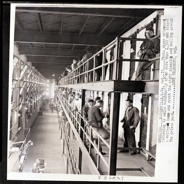 Photo shows prisoners returning to cells voluntarily after more than 1,300 men staged a mutiny here and spent the night sleeping and mulling around the prison yard.