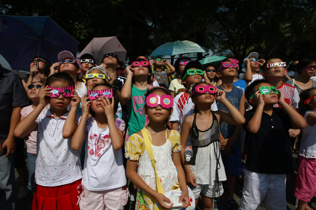 2009: A group of children observe a total solar eclipse in Wenzhou, China.