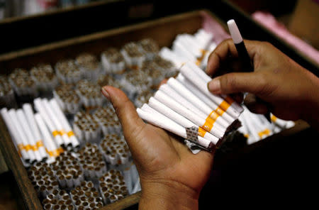 An employee counts cigarettes before packing them in Sidoarjo, Indonesia's East Java province April 7, 2010. REUTERS/Sigit Pamungkas/File Photo