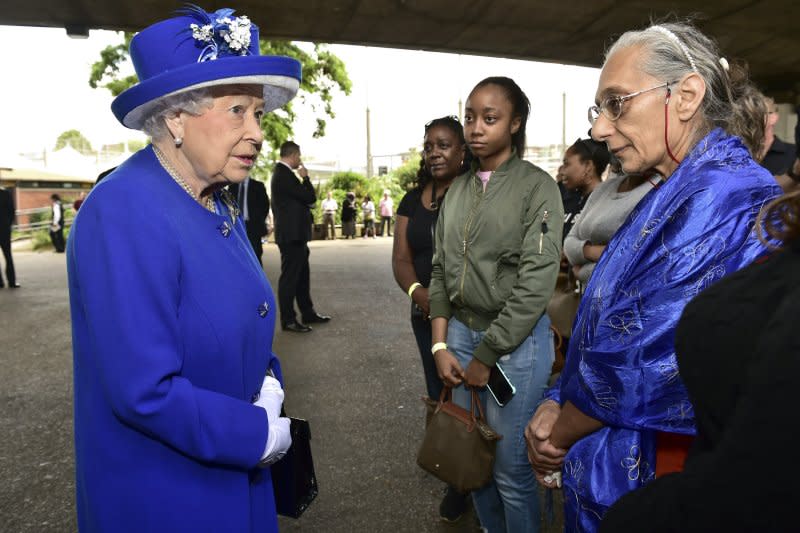 英國女王伊莉莎白二世在威廉王子的陪同下到現場慰問災民，為救援人員和義工加油打氣。(美聯社)