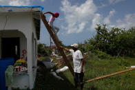 <p>Devon Warner and his daughter Che Niesha climb off of a ladder from the roof of a damaged home at Codrington on the island of Barbuda just after a month after Hurricane Irma struck the Caribbean islands of Antigua and Barbuda, October 7, 2017. REUTERS/Shannon Stapleton </p>