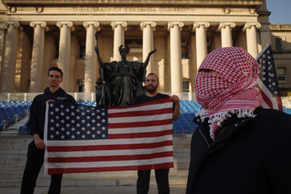 Military veterans hold a flag as they gather near a Pro-Palestine encampment on the lawn of Columbia University. James Keivom