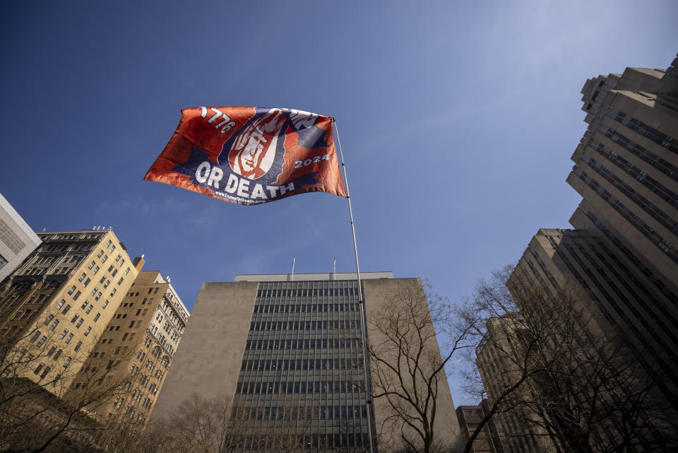 A pro-Trump flag reading Trump or Death waves near the courthouse.