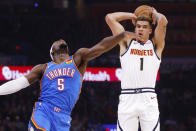 Denver Nuggets forward Michael Porter Jr. (1) passes the ball next to Oklahoma City Thunder guard Luguentz Dort (5) in the first half of an NBA basketball game, Sunday, Oct. 29, 2023, in Oklahoma City. (AP Photo/Nate Billings)