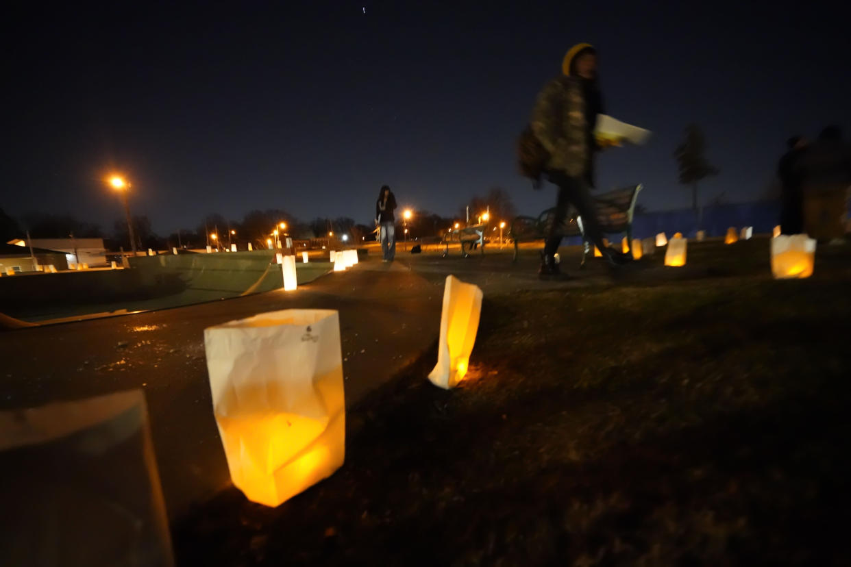 People walk past candelarias on the ground, lit by candles, after the vigil for Tyre Nichols.