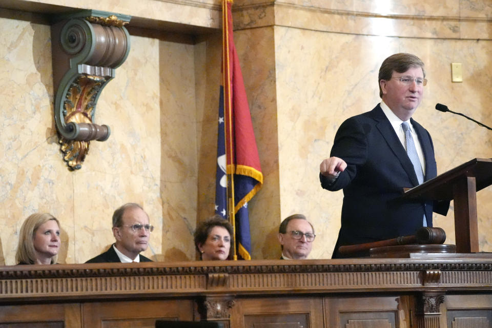 Mississippi Republican Gov. Tate Reeves, right, delivers his State of the State address to the State Legislature, as his wife Elee Reeves, from left, Republican Lt. Gov. Delbert Hosemann, wife Lynn Hosemann and Senate President Pro Tempore Sen. Dean Kirby, R-Pearl, listen, Monday, Feb. 26, 2024, at the state Capitol in Jackson, Miss. (AP Photo/Rogelio V. Solis)