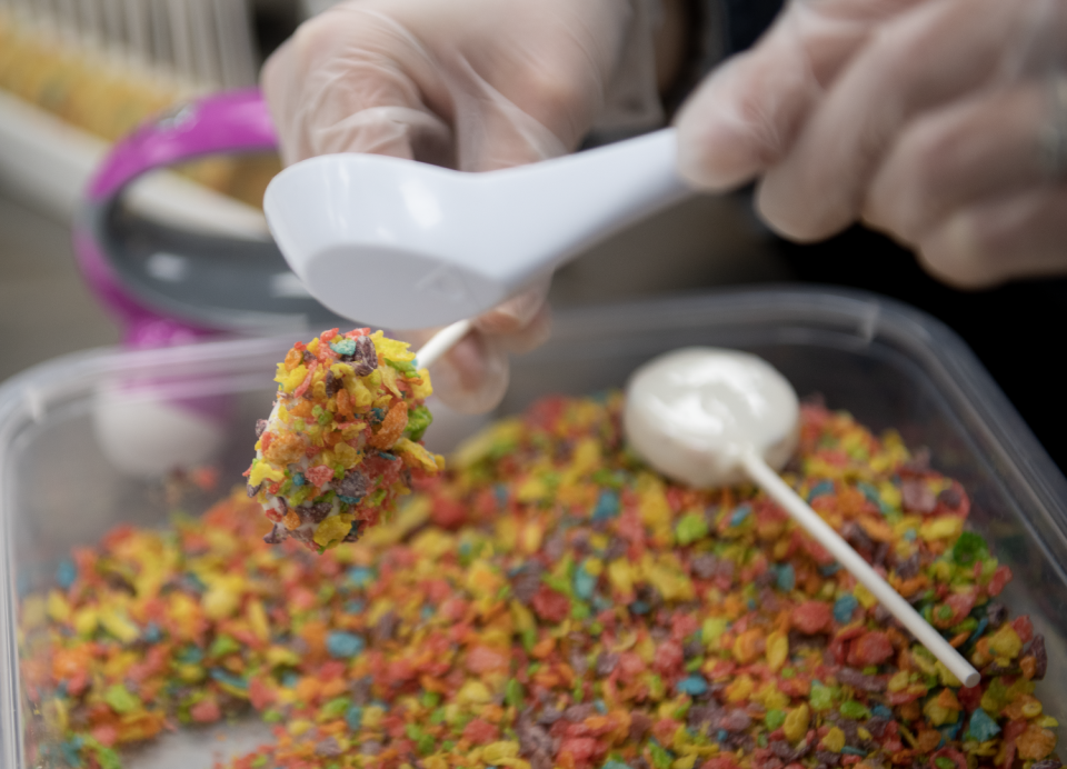 Pop artist Bethany Hammond adds Fruity Pebbles to a cake pop at Daisy Pops in Kent.