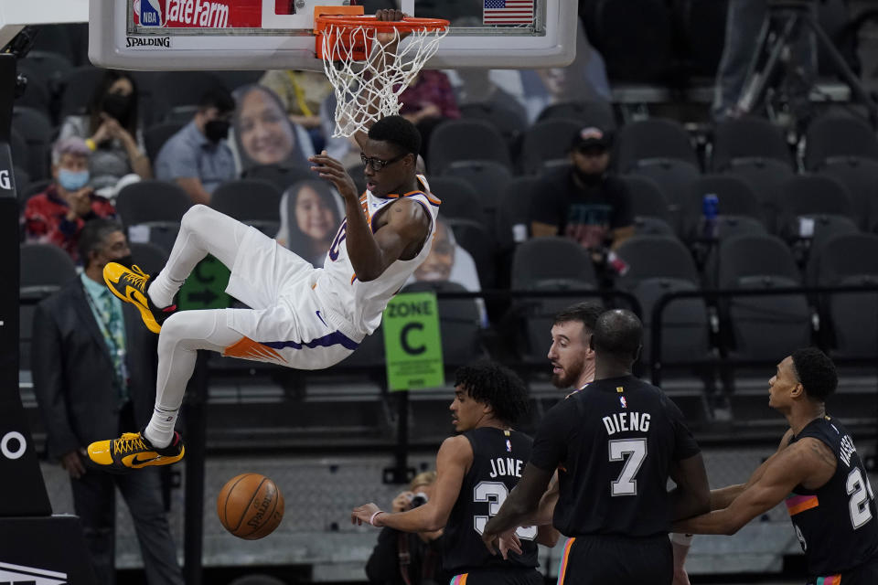 Phoenix Suns forward Jalen Smith (10) hangs on the rim as he scores against the Phoenix Suns during the second half of an NBA basketball game in San Antonio, Sunday, May 16, 2021. (AP Photo/Eric Gay)