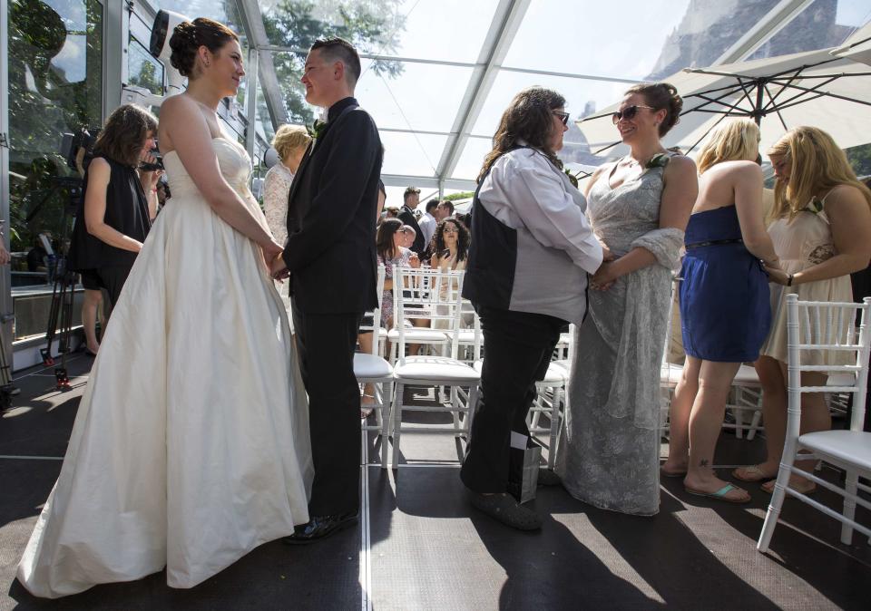 Couples take part in "The Celebration of Love", a grand wedding where over 100 LGBT couples got married, at Casa Loma in Toronto