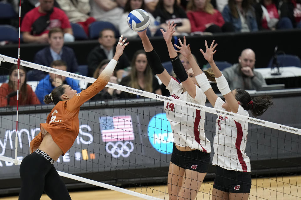Wisconsin's Anna Smrek (14) and Caroline Crawford (9) block a shot by Texas's Madisen Skinner (6) during a semifinal match in the NCAA Division I women's college volleyball tournament Thursday, Dec. 14, 2023, in Tampa, Fla. (AP Photo/Chris O'Meara)
