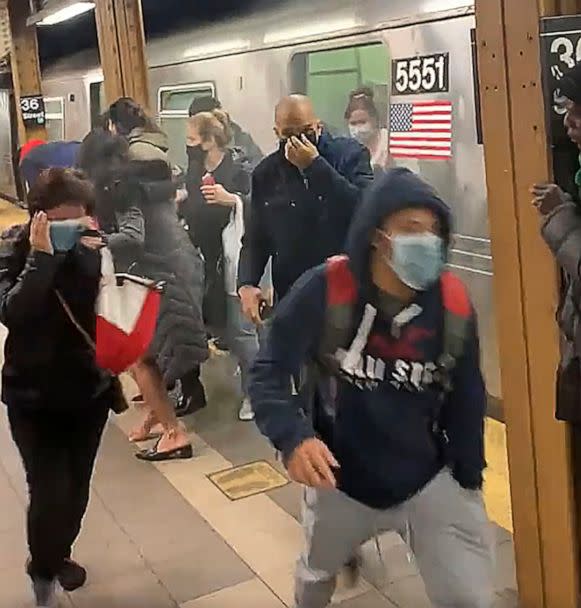 PHOTO: In this photo from social media video, passengers run from a subway car in a station in the Brooklyn borough of New York, April 12, 2022. (Will B. Wylde/AP)