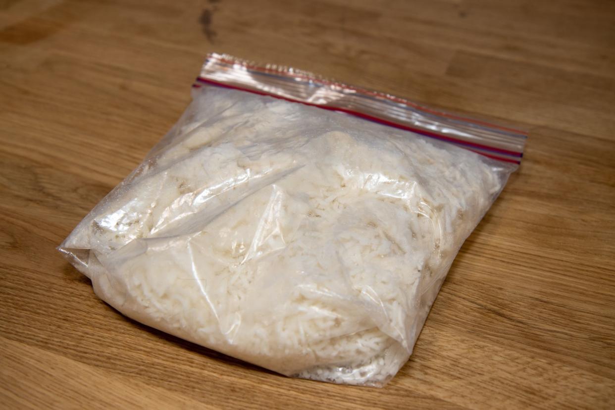 A bag of frozen white rice on a wooden kitchen work top