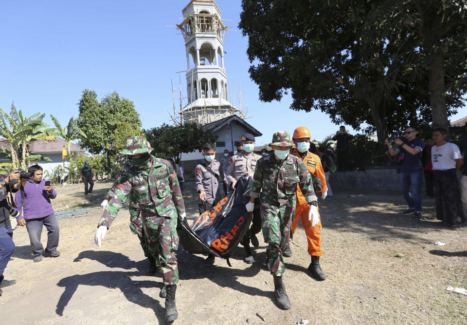 In this Tuesday, Aug. 7, 2018, photo, rescuers carry a body of an earthquake victim recovered from the collapsed Jabal Nur Mosque in North Lombok, Indonesia. (AP Photo/Tatan Syuflana)
