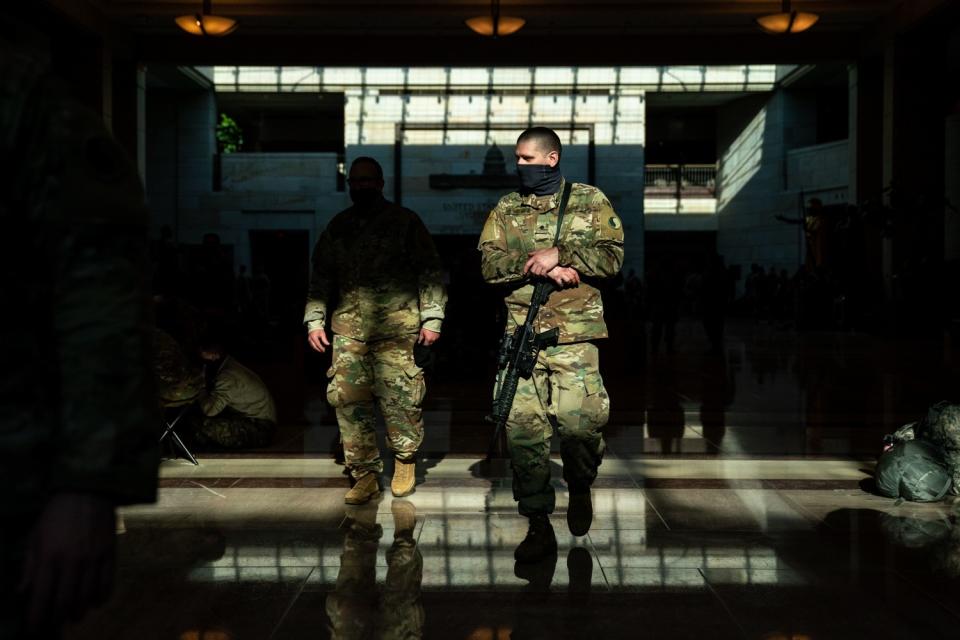 Members of the National Guard are seen in bars of sunlight.