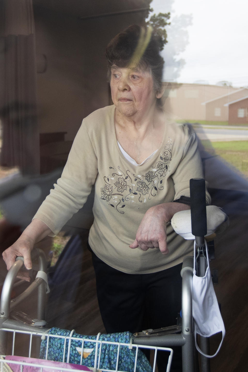 Southern Pines nursing home resident Judy Morey is seen through the window of her room during an interview in Warner Robins, Ga., on Thursday, June 25, 2020. Amid the coronavirus lockdown, she says she’s coping as best she can even as the days feel far longer than any that came before. “All I kind of want to do is taking naps all day long out of boredom,” she says. (AP Photo/John Bazemore)