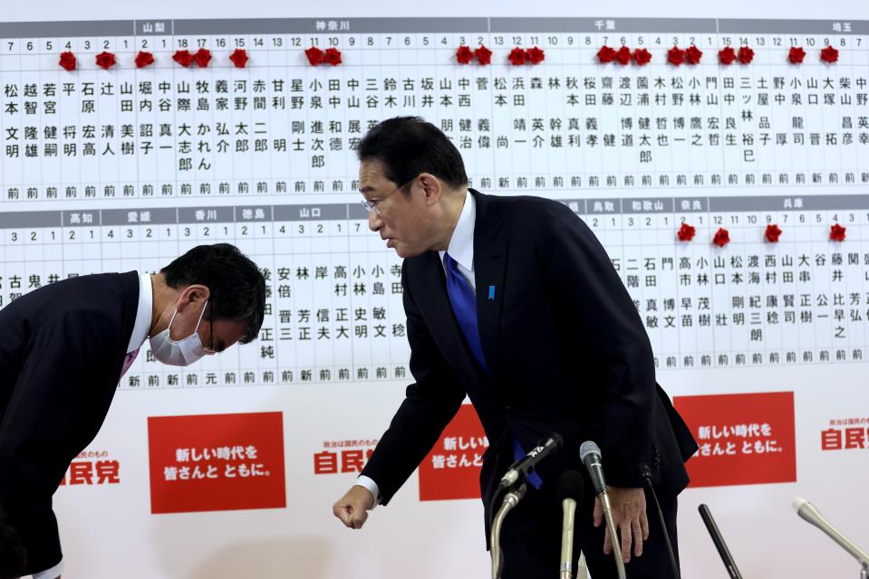 Japan's former foreign minister and senior member of the Liberal Democratic Party Taro Kono, left, bows to Prime Minister and party leader Fumio Kishida at the party headquarters in Tokyo, Sunday, Oct. 31, 2021. Japanese Prime Minister Fumio Kishida’s governing coalition is expected to keep a majority in a parliamentary election Sunday but will lose some seats in a setback for his weeks-old government grappling with a coronavirus-battered economy and regional security challenges, according to exit polls. (Behrouz Mehri, Pool via AP)