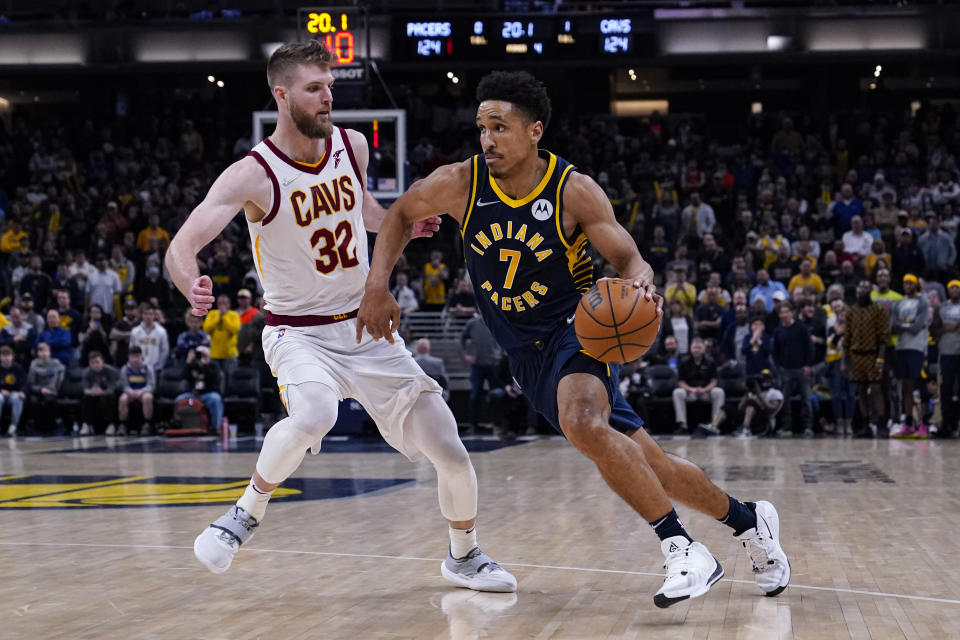 Indiana Pacers guard Malcolm Brogdon (7) drives on Cleveland Cavaliers forward Dean Wade (32) during the second half of an NBA basketball game in Indianapolis, Tuesday, March 8, 2022. The Cavaliers won 127-124. (AP Photo/Michael Conroy)