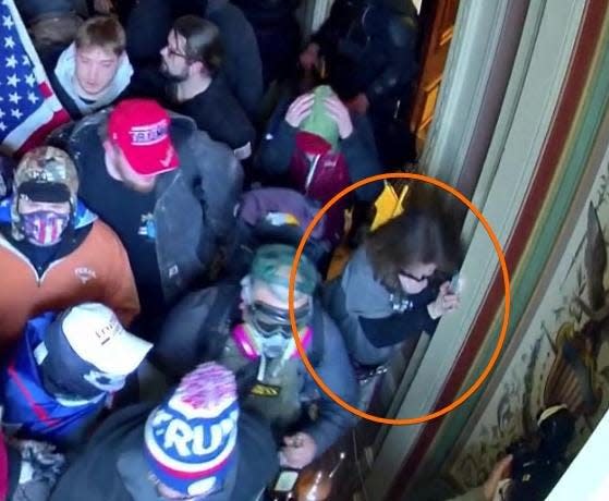 A woman inside the U.S. Capitol on Jan. 6 wearing the same clothing Sandra Atkinson wore on the march toward the building.