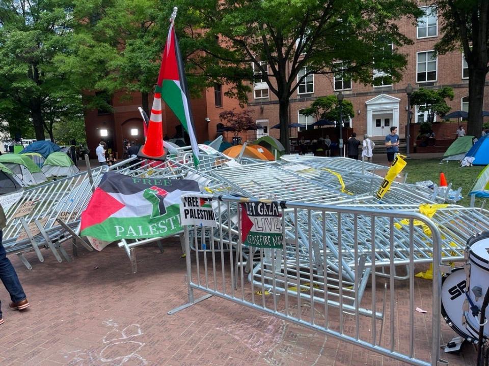 Security barriers and Palestinian flags are piled at the center of the square where George Washington University students have formed an encampment.