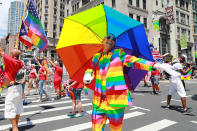 <p>A marcher carrying an umbrella and dressed as a rainbow gestures for the camera during the N.Y.C. Pride Parade in New York on June 25, 2017. (Photo: Gordon Donovan/Yahoo News) </p>