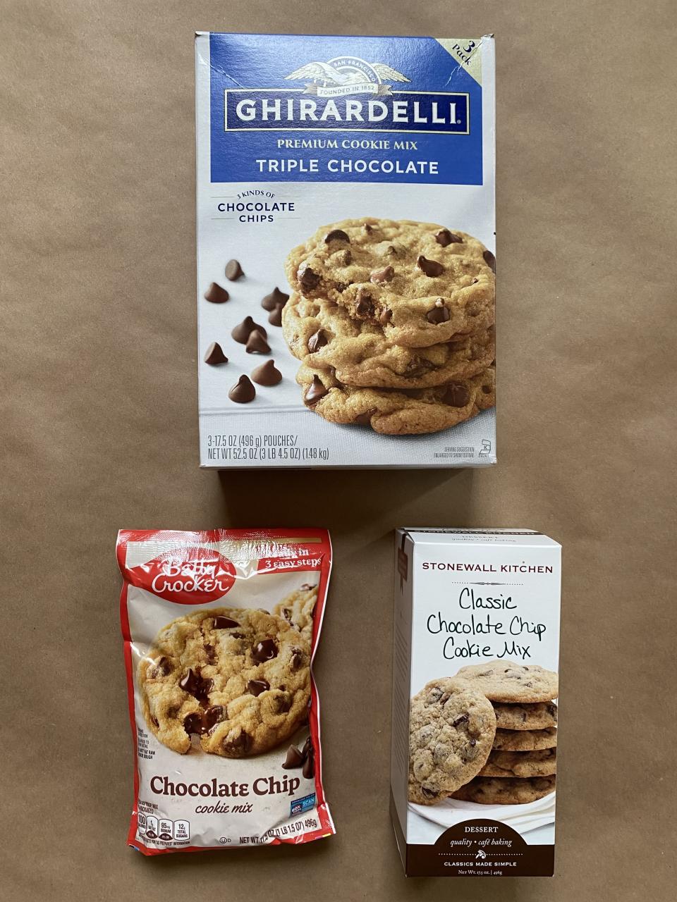 Ghirardelli Triple Chocolate cookie mix, Betty Crocker Chocolate Chip cookie mix, and Stonewall Kitchen Classic Chocolate Chip Cookie Mix placed on a surface