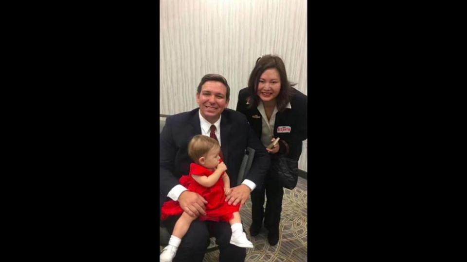 Now-Gov. Ron DeSantis, with his daughter, Madison, seated on his lap, poses for a picture with Li ‘Cindy’ Yang at the Embassy Suites by Hilton Boca Raton on Jan. 29, 2018, the day he began his successful campaign