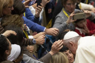 Pope Francis salutes faithful in the Paul VI Hall at the Vatican at the end of an audience with members of parish evangelization services, Monday, Nov. 18, 2019. (AP Photo/Alessandra Tarantino)