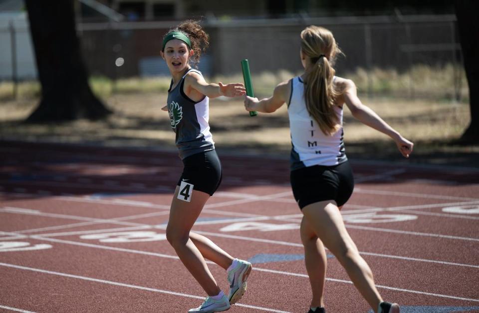 Pitman’s Adeline Persons hands to the baton to teammate Emerson Newton in the 4x800 relay in the Central California Athletic League Championships at Downey High School in Modesto, Calif., Wednesday, May 1, 2024. Pitman won the race with a time of 11:08.58.