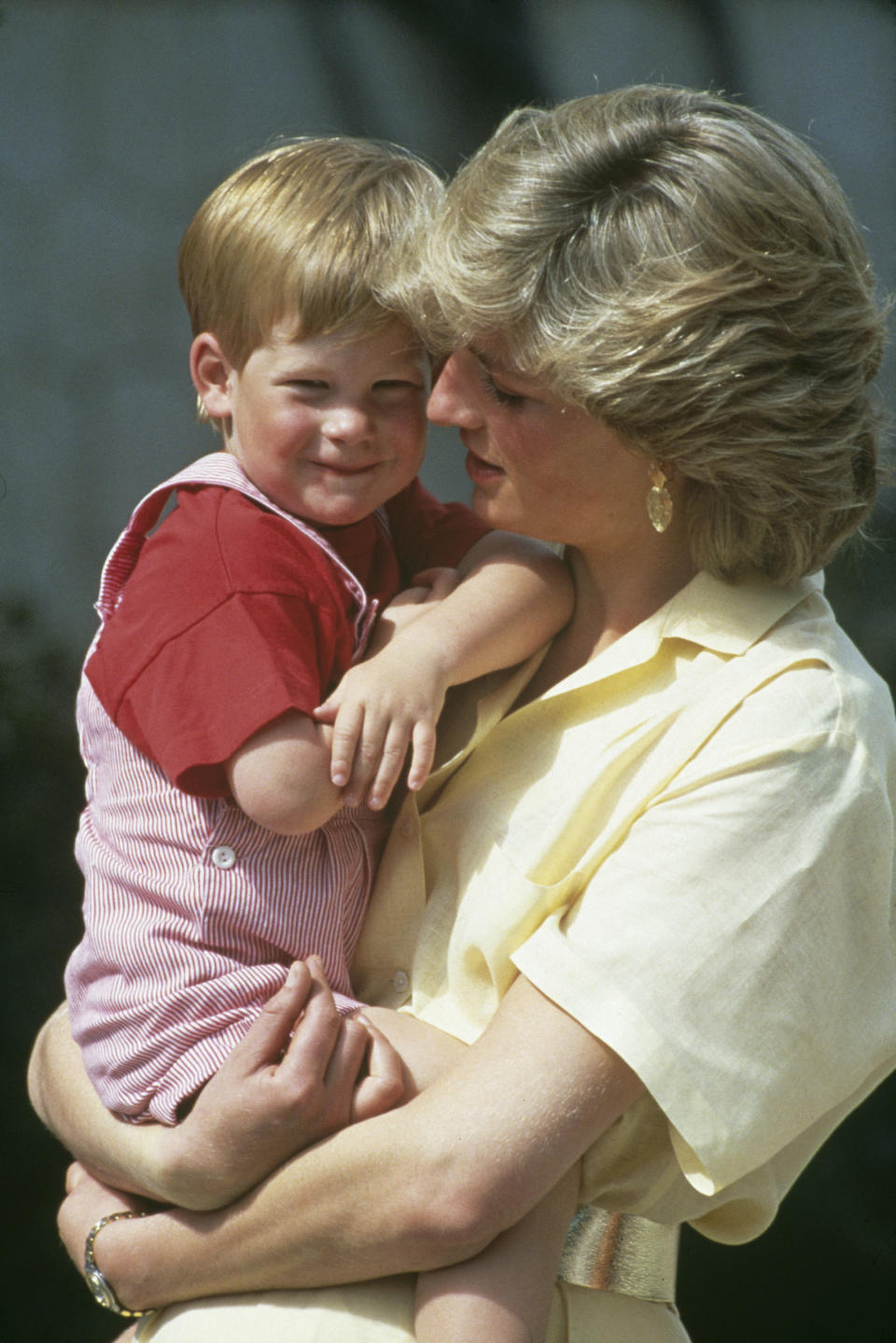 Diana, Princess Of Wales (1961 - 1997) carrying her son, Prince Harry, at a photocall during their summer holiday at the Spanish Royal Palace of La Almudaina, just outside Palma, Majorca, Spain, 8th August 1987. (Photo by Tim Graham Photo Library via Getty Images)