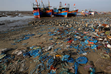 FILE PHOTO: Fishing boats are seen at a beach covered with plastic waste in Thanh Hoa province, Vietnam June 4, 2018. REUTERS/Nguyen Huy Kham/File Photo