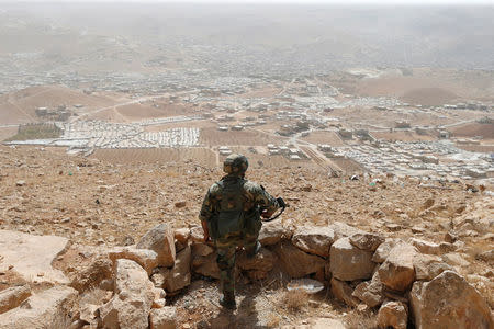 FILE PHOTO: A Lebanese soldier carries his weapon as he stands at an army post in the hills above the Lebanese town of Arsal, near the border with Syria, Lebanon September 21, 2016. Picture taken September 21, 2016. REUTERS/Mohamed Azakir/File photo