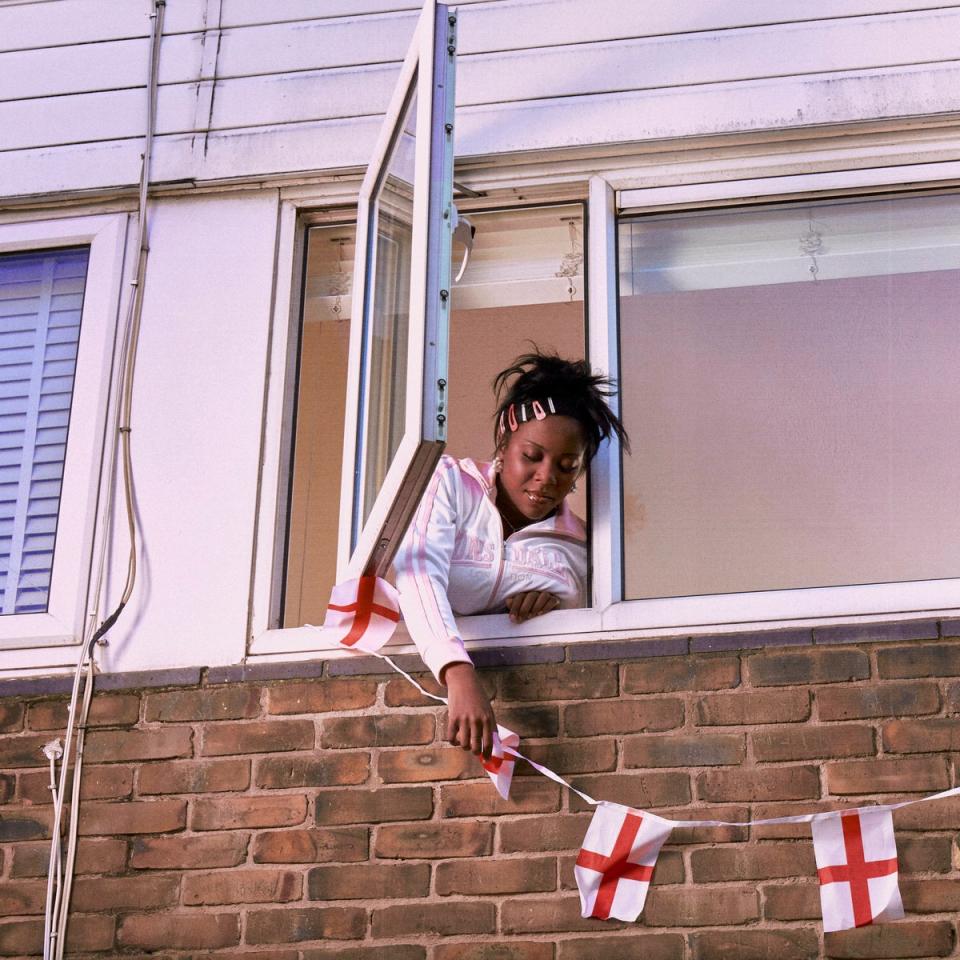 Chinouriri hangs St George’s Cross bunting out the window on her accompanying album artwork (Parlophone)