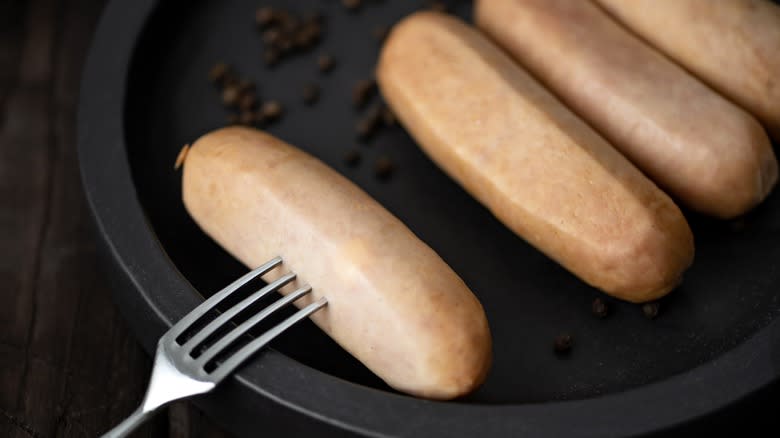 Pricking sausage with a fork 