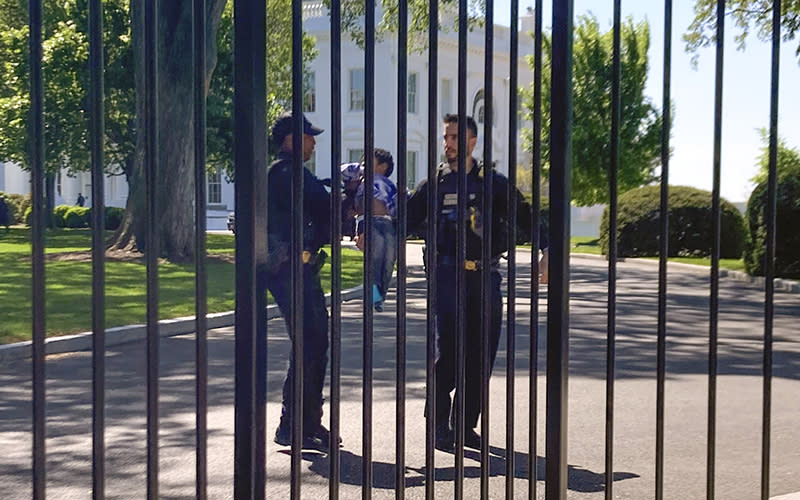 Secret Service uniformed division police officers carry a young child who crawled through the White House fence