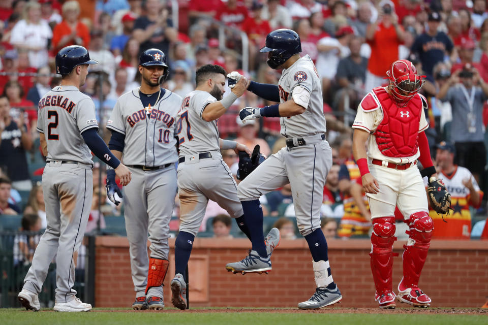 Houston Astros' Carlos Correa is congratulated by teammates Alex Bregman (2), Yuli Gurriel (10) and Jose Altuve (27) after hitting a grand slam as St. Louis Cardinals catcher Andrew Knizner, right, stands by during the third inning of a baseball game Saturday, July 27, 2019, in St. Louis. (AP Photo/Jeff Roberson)