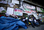 People, some in danger of being evicted from their homes for not being able to keep up with mortgage payments, prepare some documents as they camp outside a Bankia bank in Madrid. The main banners read: 'Rescue people, Bankia is ours - your houses are ours too, Stop evictions'