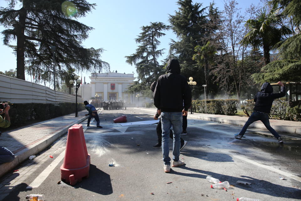 Protesters throw stones at riot police as thousands of opposition supporters protest in Tirana, Albania on Saturday, March 16, 2019. Albanian opposition supporters clashed with police while trying to storm the parliament building Saturday in a protest against the government which they accuse of being corrupt and linked to organized crime.(AP Photo/Visar Kryeziu)