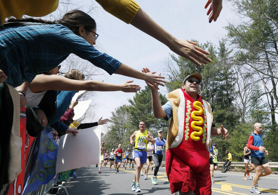 FILE -- In this April 15, 2013 file photo, a man dressed as a hot dog runs through Wellesley, Mass., during the 117th running of the Boston Marathon. Security will be tightened for the 2014 Boston Marathon after twin explosions killed three people and injured more than 260 near the finish line of the race in 2013. New rules include a limit on the size of water bottles, restrictions on bulky costumes, and nothing covering the face.(AP Photo/Michael Dwyer, File)