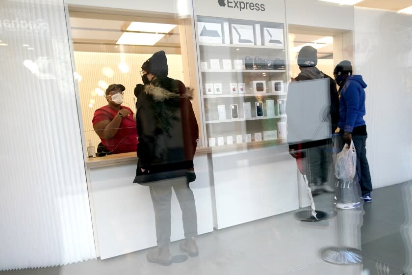 Customers pick up online orders at the Apple Store at the Towson Town Center, Dec. 15, 2020, in Towson, Md. Apple store employees in the Baltimore suburb voted to unionize by a nearly 2-to-1 margin on Saturday, June 18, 2022. (AP Photo/Julio Cortez, file)