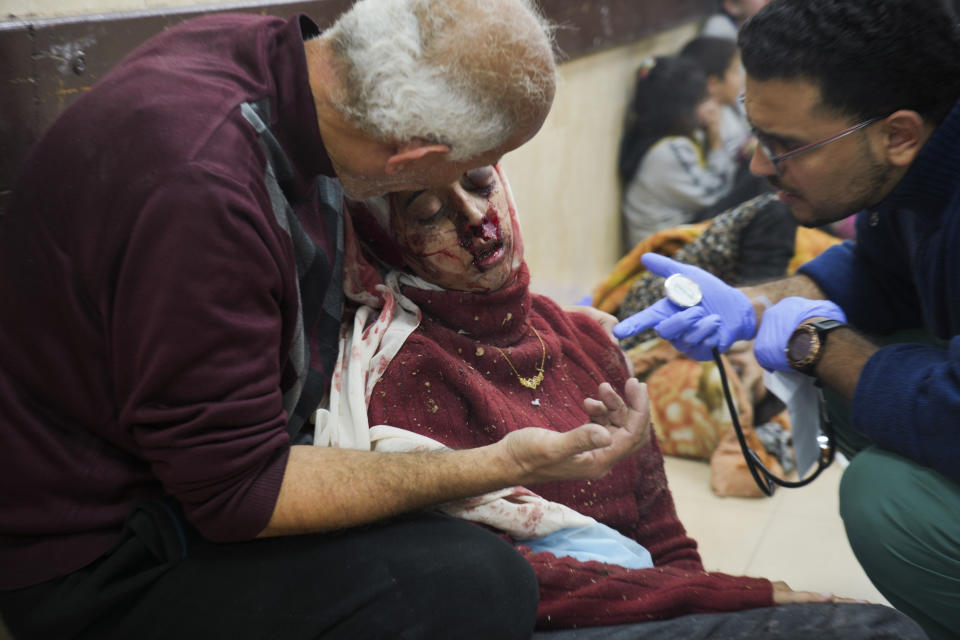 Palestinians wounded in Israeli bombardment are helped in a hospital in Deir al Balah, Monday, Jan. 1, 2024. (AP Photo/Hatem Moussa)