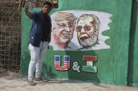 A man takes a selfie with portraits of U.S. President Donald Trump and Indian Prime Minister Narendra Modi painted on a wall ahead of Trump's visit, in Ahmadabad, India, Tuesday, Feb. 18, 2020. Trump is scheduled to visit the city during his Feb. 24-25 India trip. (AP Photo/Ajit Solanki)