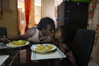 Deported from the United States a day before, Delta de Leon and her 2-year-old daughter Chloe share a kiss in their temporary home, in Port-au-Prince, Haiti, Thursday, Sept. 23, 2021. Breakfast on that first morning in Haiti consisted of spaghetti and bits of avocado. Normally, Chloe has milk and fruit, but de Leon said she was waiting on a money transfer to buy some basic food items. (AP Photo/Joseph Odelyn)