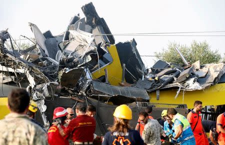 Rescuers work at the site where two passenger trains collided in the middle of an olive grove in the southern village of Corato, near Bari, Italy, July 12, 2016. REUTERS/Alessandro Garofalo