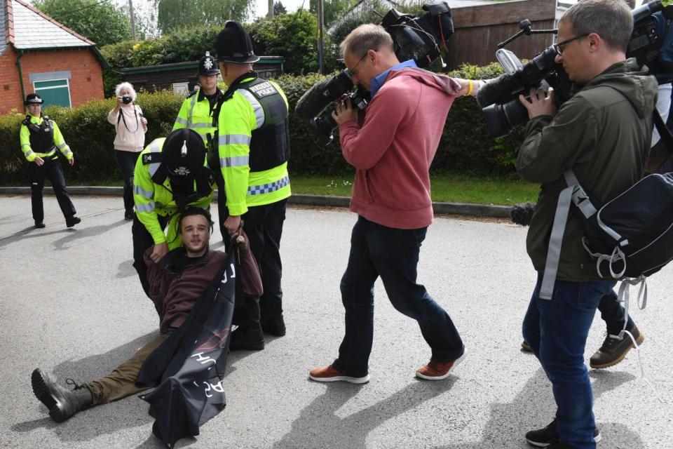 The protester is held by police outside the community centre in Wrexham (AFP/Getty Images)