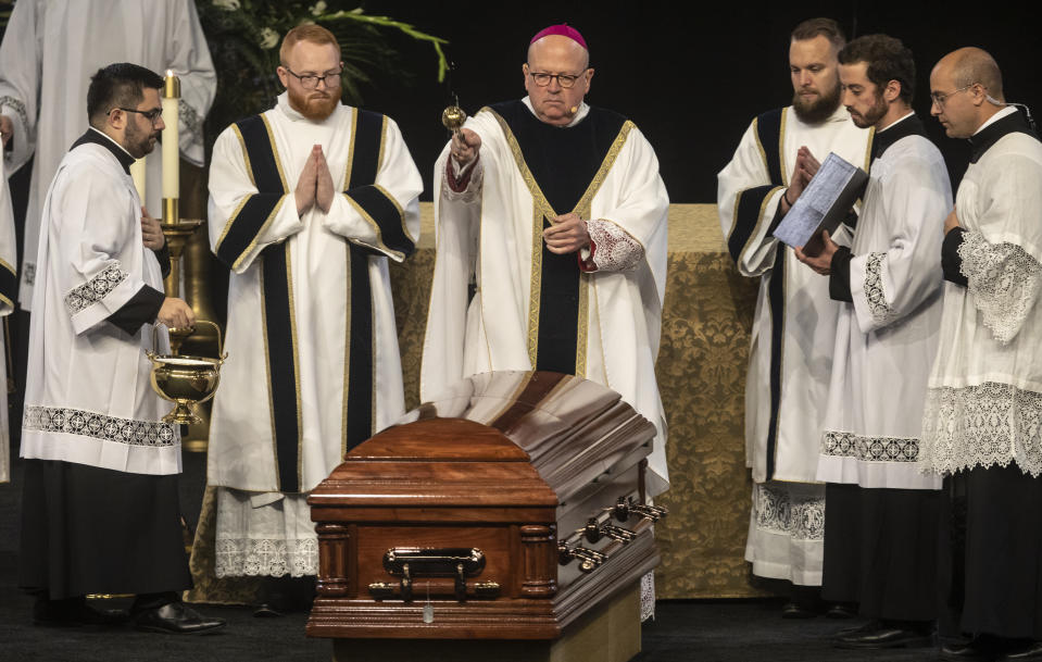 Bishop Carl Kemme of the Wichita Diocese, sprinkles holy water on the casket of Father Emil Kapaun during Kapaun's funeral mass on Wednesday, Sept., 29, 2021 in Wichita, Kan. Kapaun died in a North Korean POW camp in May of 1951. He was posthumously awarded the Medal of Honor in 2013 for his bravery in the Korean War. Kapaun's remains were identified earlier this year returned home to Kansas recently. (Travis Heying/The Wichita Eagle via AP)